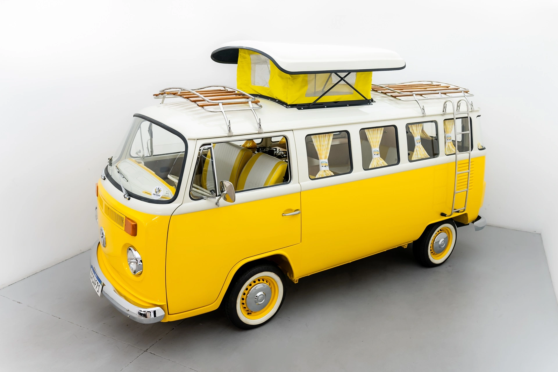 Aangepaste gele Volkswagen T2 camper met een gemodificeerde motor en airconditioning.
